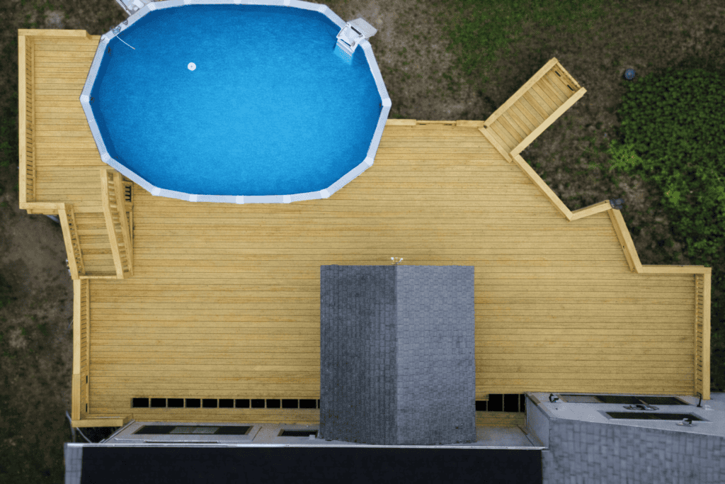 Overhead aerial of a custom pool deck built by Kilted Builders, featuring pressure-treated decking around an above-ground pool in New Hampshire