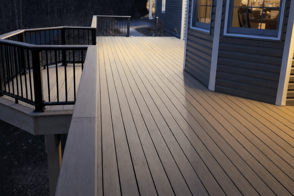 Custom composite deck with black aluminum railing built in New Hampshire by Kilted Builders.